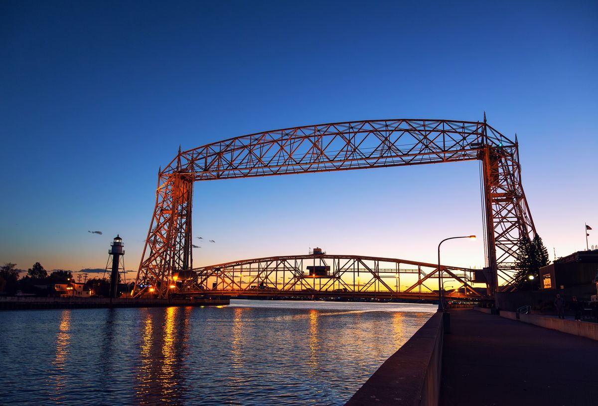 Duluth&rsquo;s Aerial Lift Bridge glowing at sunset over the ship canal